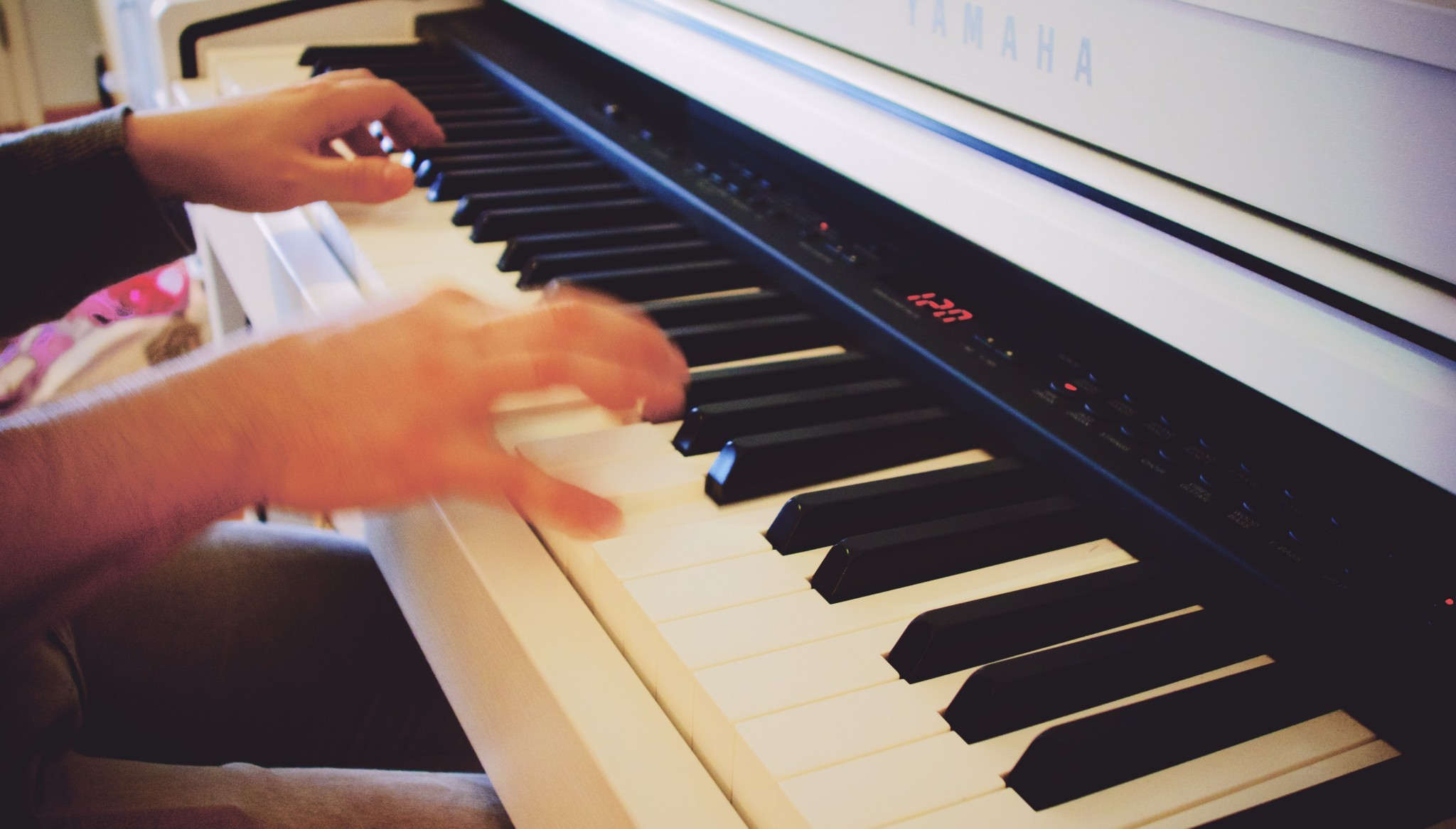 Băiat cântând la pian, se văd numai mâinile pe clape