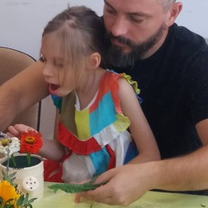 tată și fiică aranjează flori în vas