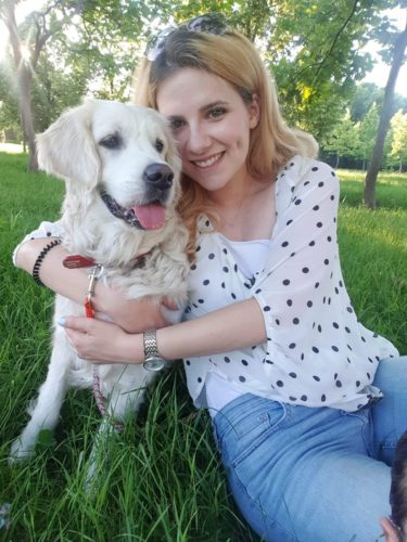 Câinele Summer și terapeutul Tania. Tania are părul mediu, zâmbește și îmbrățișează câinele. Câinele este de talie mare, blană cu păr lung și ondulat, urechi mari.