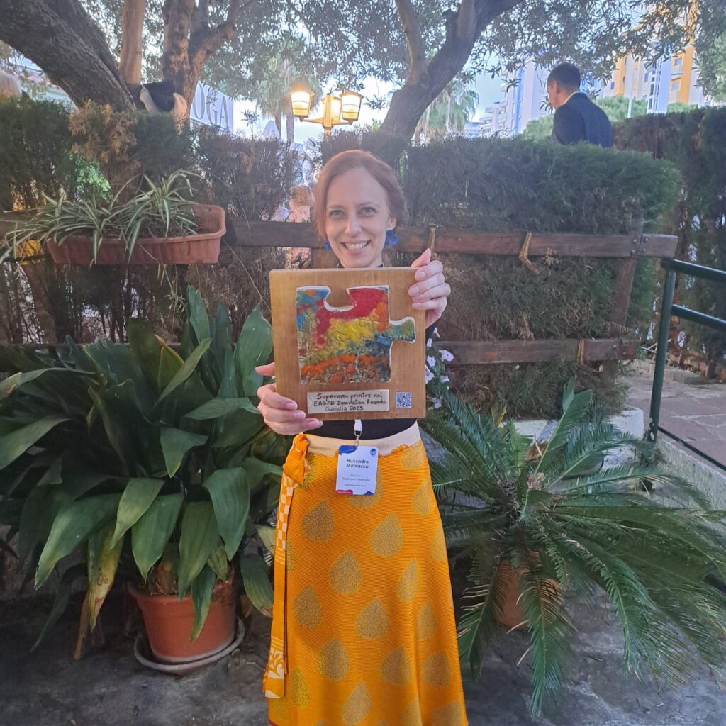 Ruxandra Mateescu ține premiul primit în mână și râde fericită.